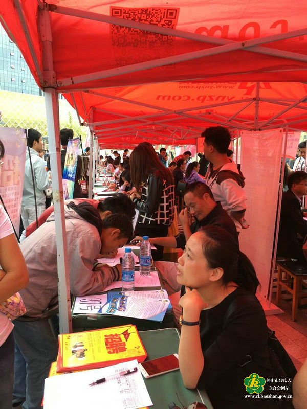 (招聘会上,求职残疾人积极询问企业相关事宜)