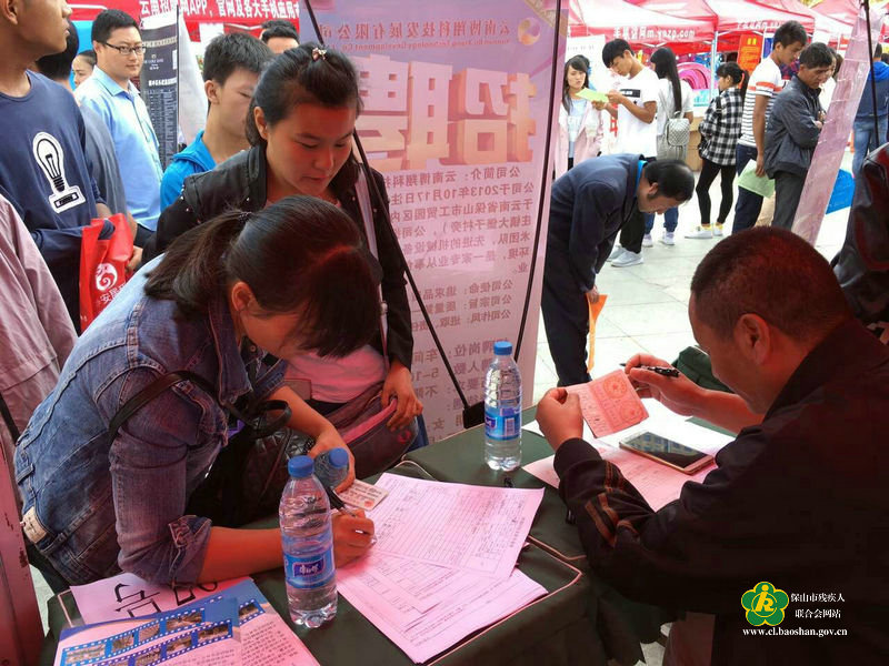 (招聘会上,求职残疾人积极询问企业相关事宜)