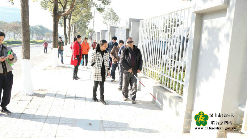 图为:组织视力残疾人进行户外平路行走实践